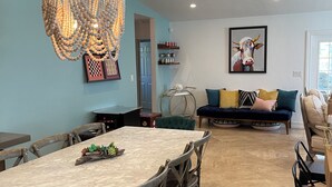 A dining area with a marble table, wooden chairs, and a decorative chandelier. - Villa Palma - Walk to Beach Pool House! Location Location Location (Naples)