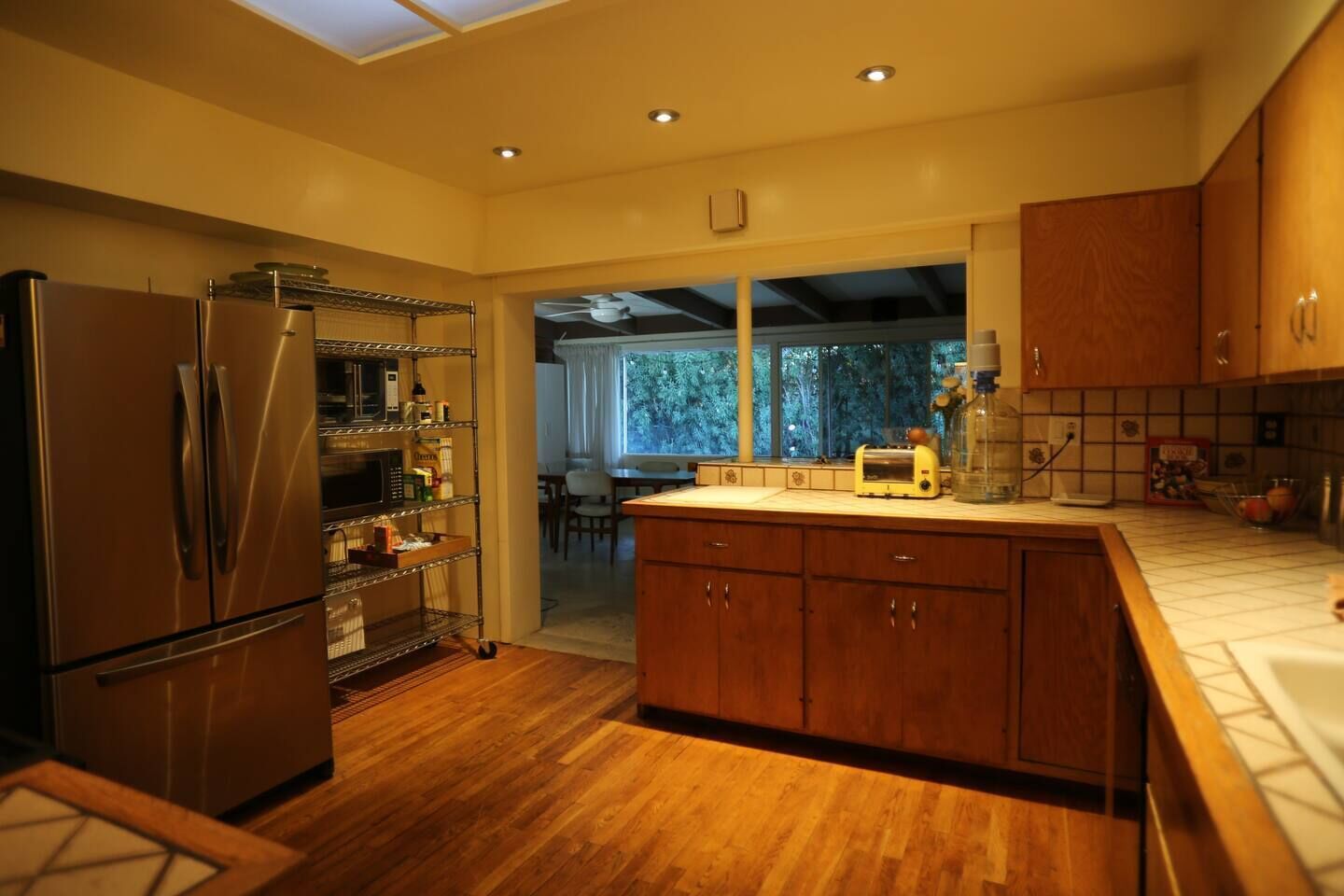 A modern kitchen with wooden cabinets, stainless steel appliances, and a wooden countertop.