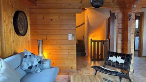 A cozy wooden interior with a sofa, a bench, a wall clock, and a staircase leading to another room. - Authentic chalet for 6 pers - A charming place 5 min from Nendaz station  (Nendaz)