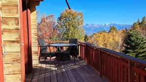 A wooden deck with a table and chairs, overlooking a mountainous landscape with autumn foliage. - Authentic chalet for 6 pers - A charming place 5 min from Nendaz station  (Nendaz)