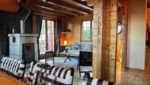 A cozy cabin interior with a stone fireplace, wooden walls, a sofa, and a dining table. - Authentic chalet for 6 pers - A charming place 5 min from Nendaz station  (Nendaz)