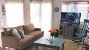 A living room with a sofa, coffee table, and TV. - Spacious 4-bedroom condo steps from The Starboard in Dewey Beach (Dewey Beach)