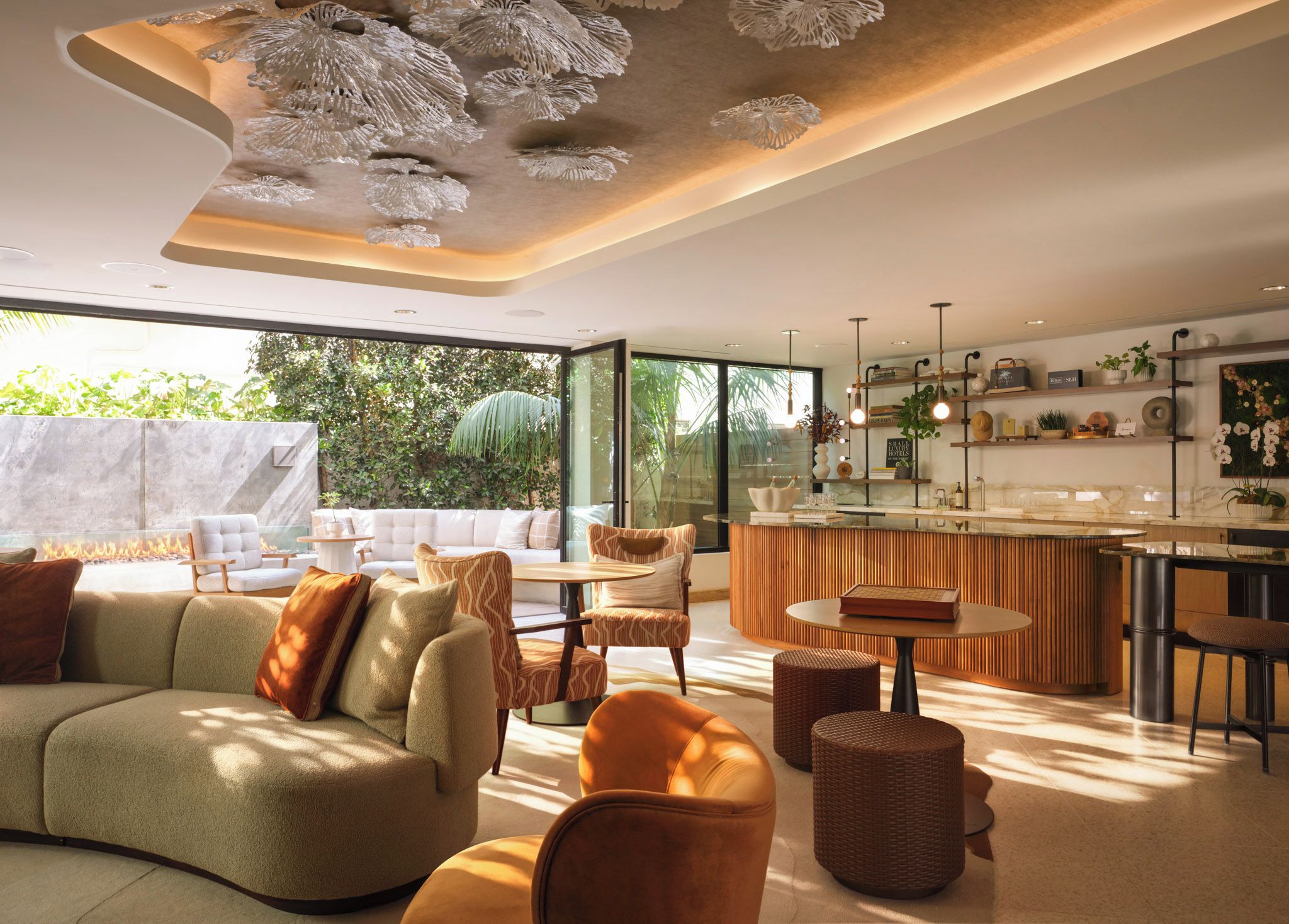 Een moderne woonkamer met een bank, stoelen, een salontafel en een eethoek met een bar.