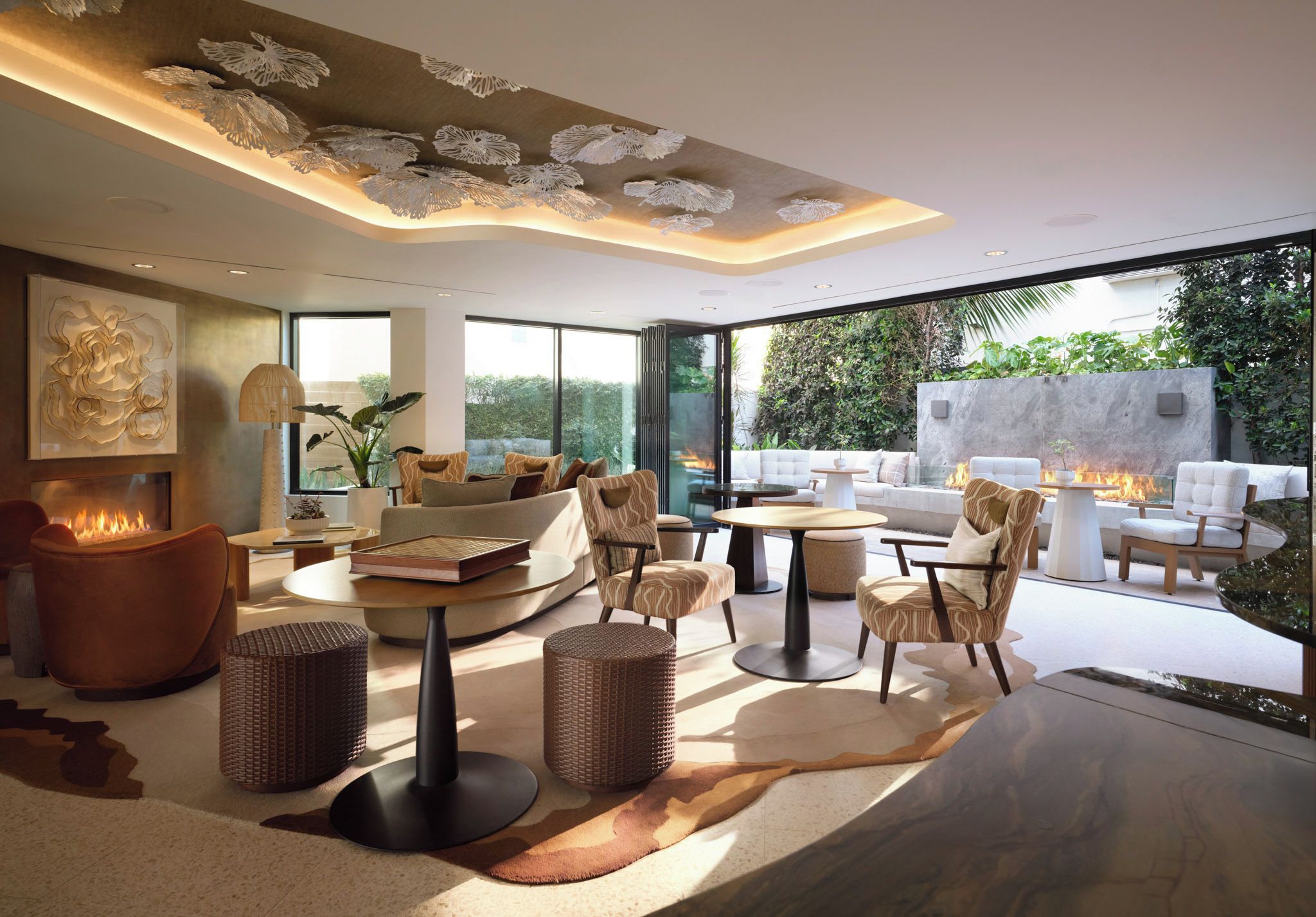 A modern living room with a fireplace, comfortable seating, and a view of the outdoors.