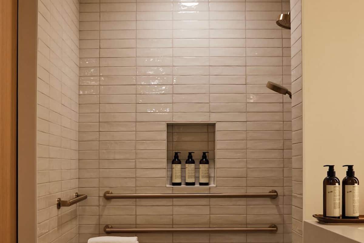 Een bad/douchecombinatie, designer toiletartikelen, een haardroger
