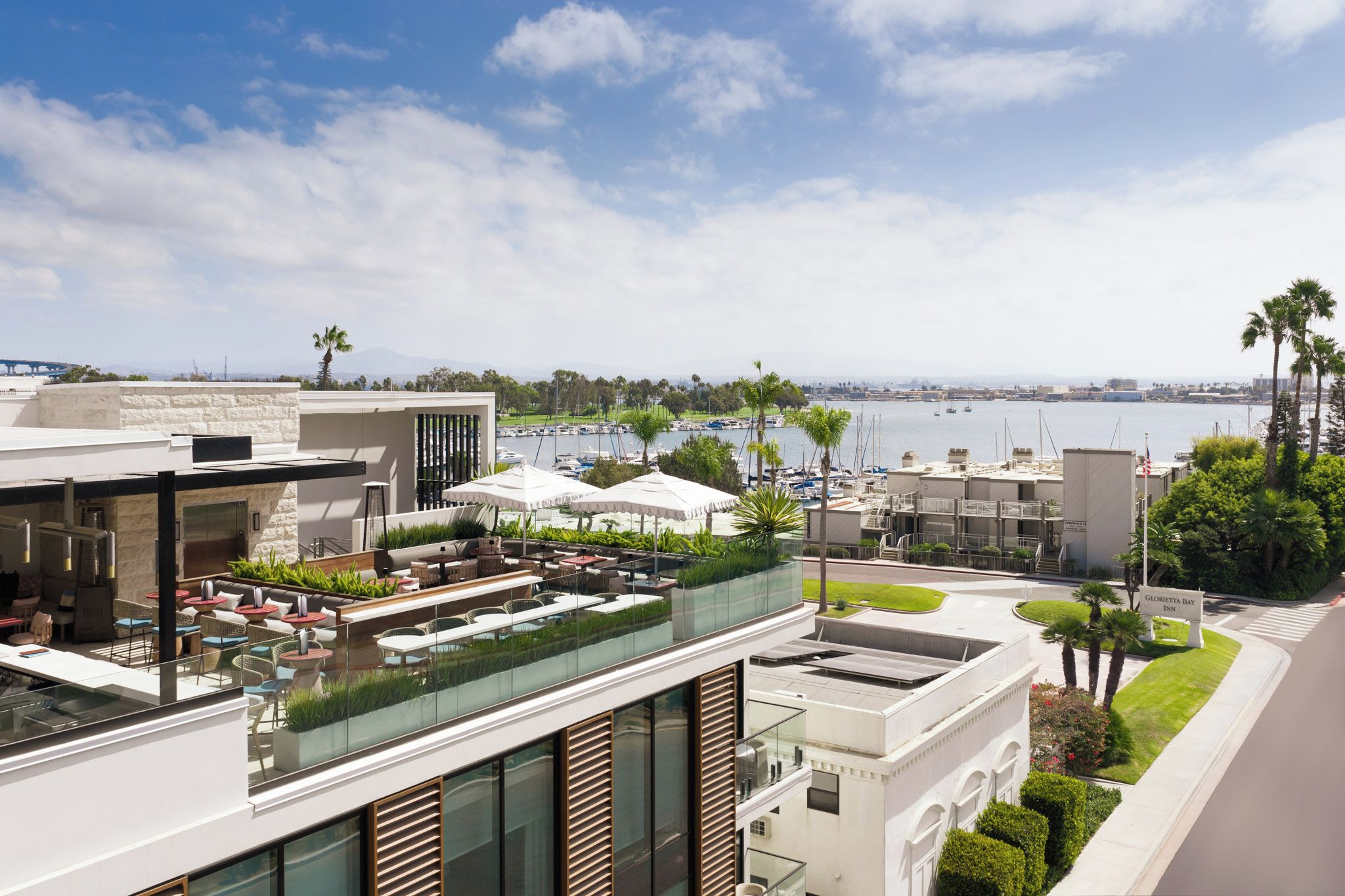 A rooftop bar with outdoor seating and a view of the marina.