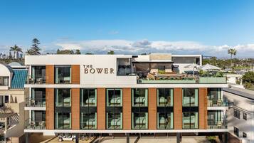 A modern hotel with a flat roof, large windows, and a sign reading "The Bower".