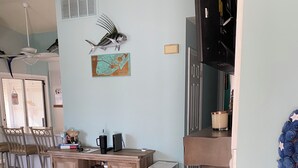 Ein Essbereich mit Holztisch und -stühlen, einer Karte an der Wand und einer kleinen Küchenzeile mit Kühlschrank und Mikrowelle.