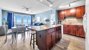 A modern kitchen with wooden cabinets, a granite countertop, and a built-in oven. - Laketown Wharf 1608- Turtle Tower (Panama City Beach)