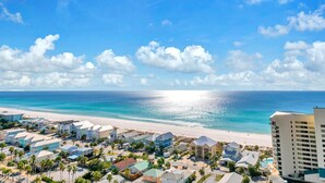 A coastal town with beachfront properties, a clear sky, and a calm sea. - Laketown Wharf 1608- Turtle Tower (Panama City Beach)