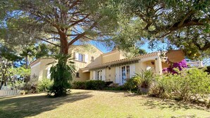 A Mediterranean-style house with a tiled roof, surrounded by lush greenery and a well-maintained lawn. - Spacious house with garden (Sanary-sur-Mer)