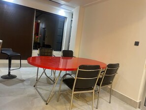 A conference room with a red table and four black chairs. - Blue Angel Annexe (Shillong)