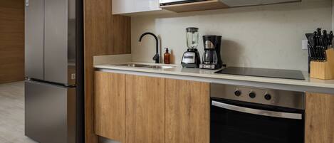 Una cocina moderna con refrigerador de acero inoxidable, microondas, cafetera y lavavajillas.