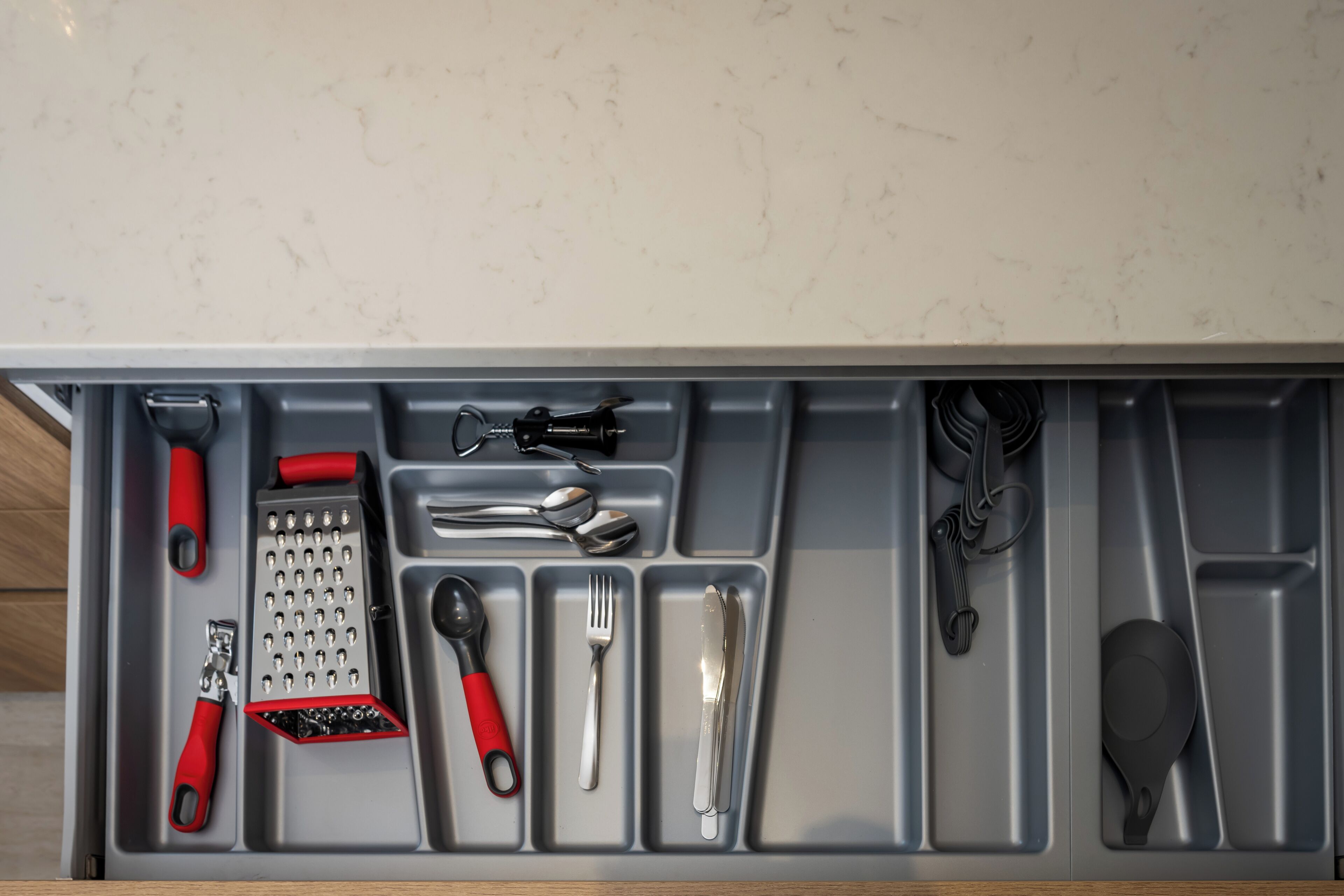 A kitchen drawer with utensils and appliances.
