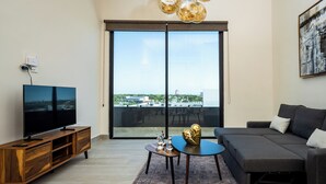 Una sala de estar moderna con un televisor de pantalla plana, mueble de entretenimiento de madera y un sofá.