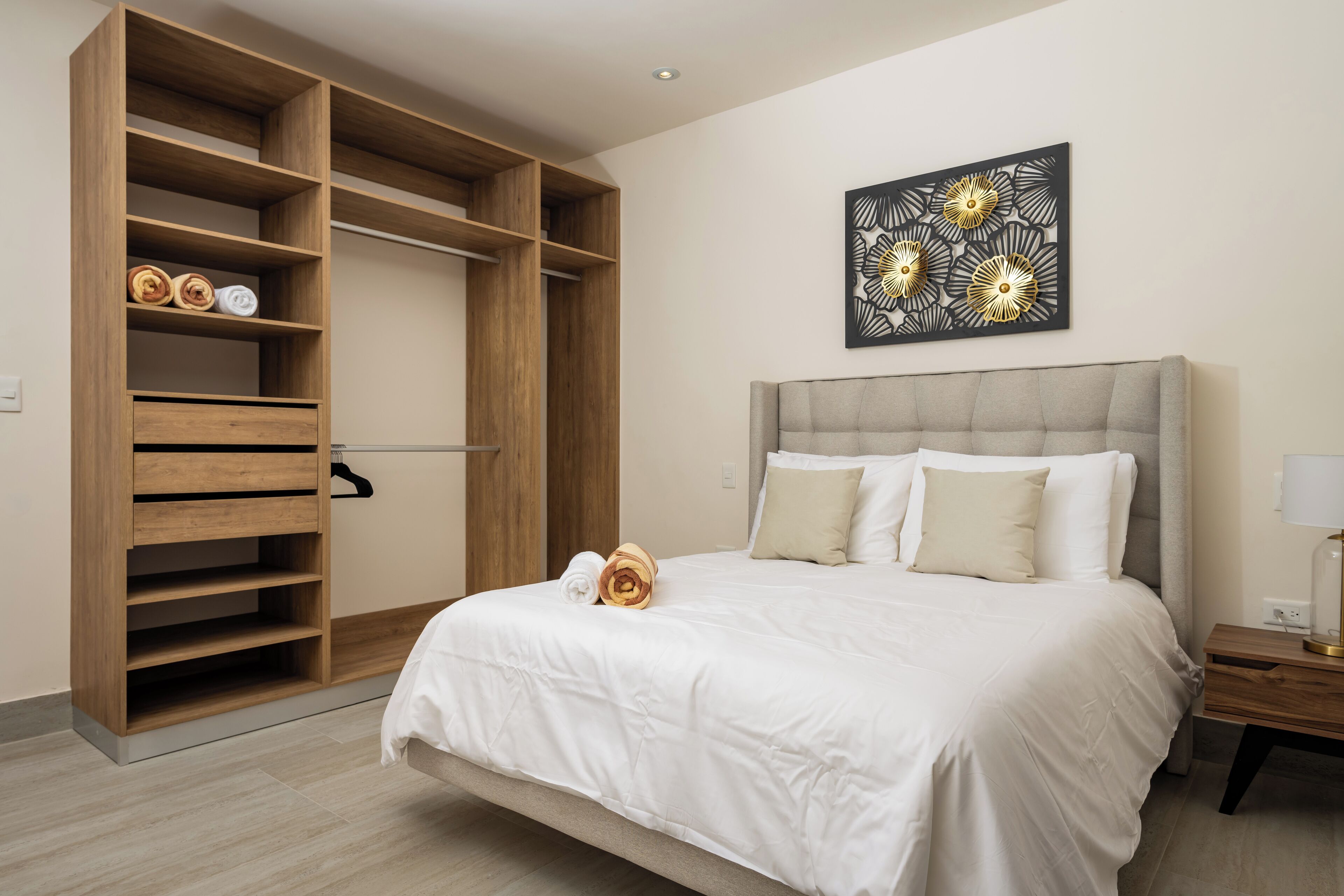 Un dormitorio con una cama grande, un armario de madera y una obra de arte colgada en la pared.