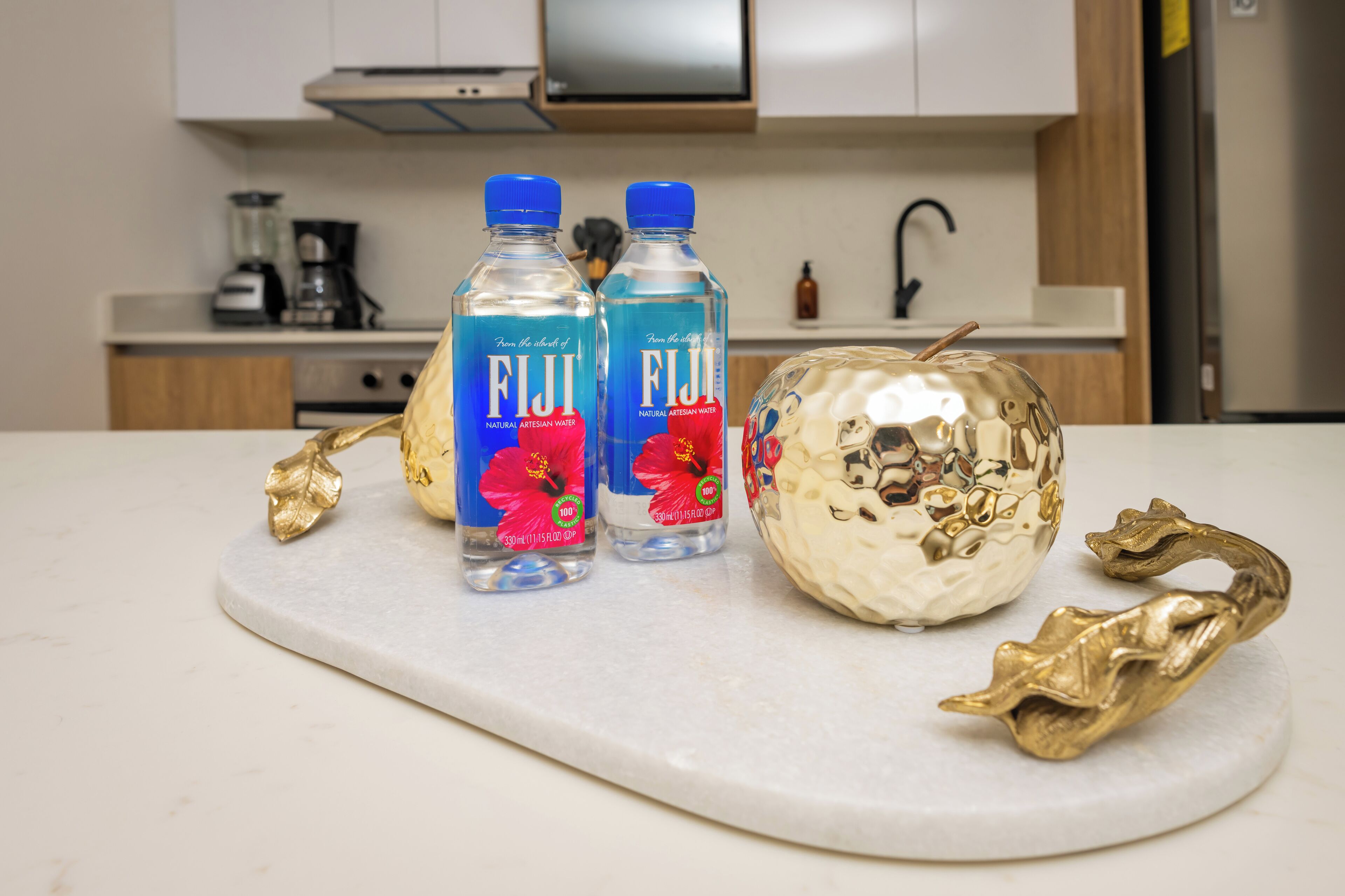 Dues amples de Fiji sobre una taulell de marbre amb fulles daurades decoratives.