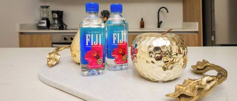 Dues amples de Fiji sobre una taulell de marbre amb fulles daurades decoratives.