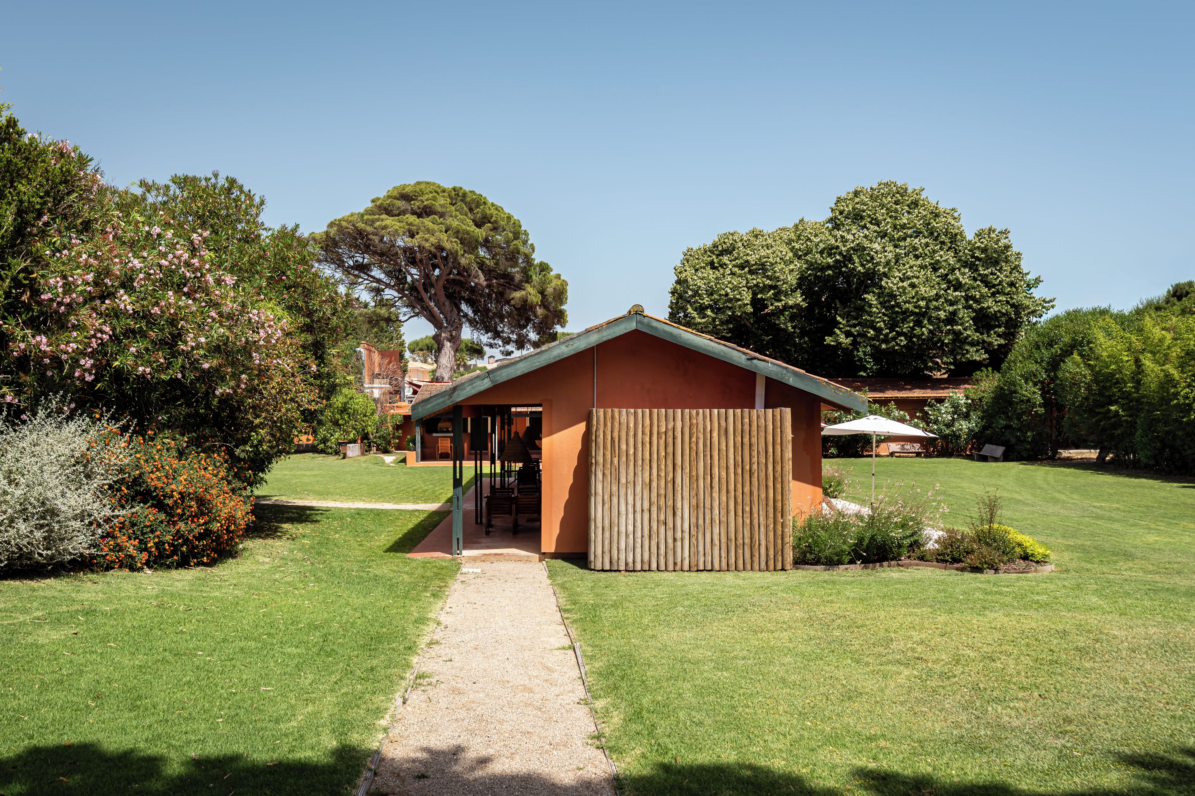 A house with a gravel path leading to a wooden fence.