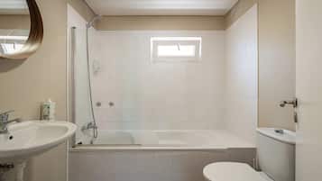 Een badkamer met een bad, toilet en wastafel.