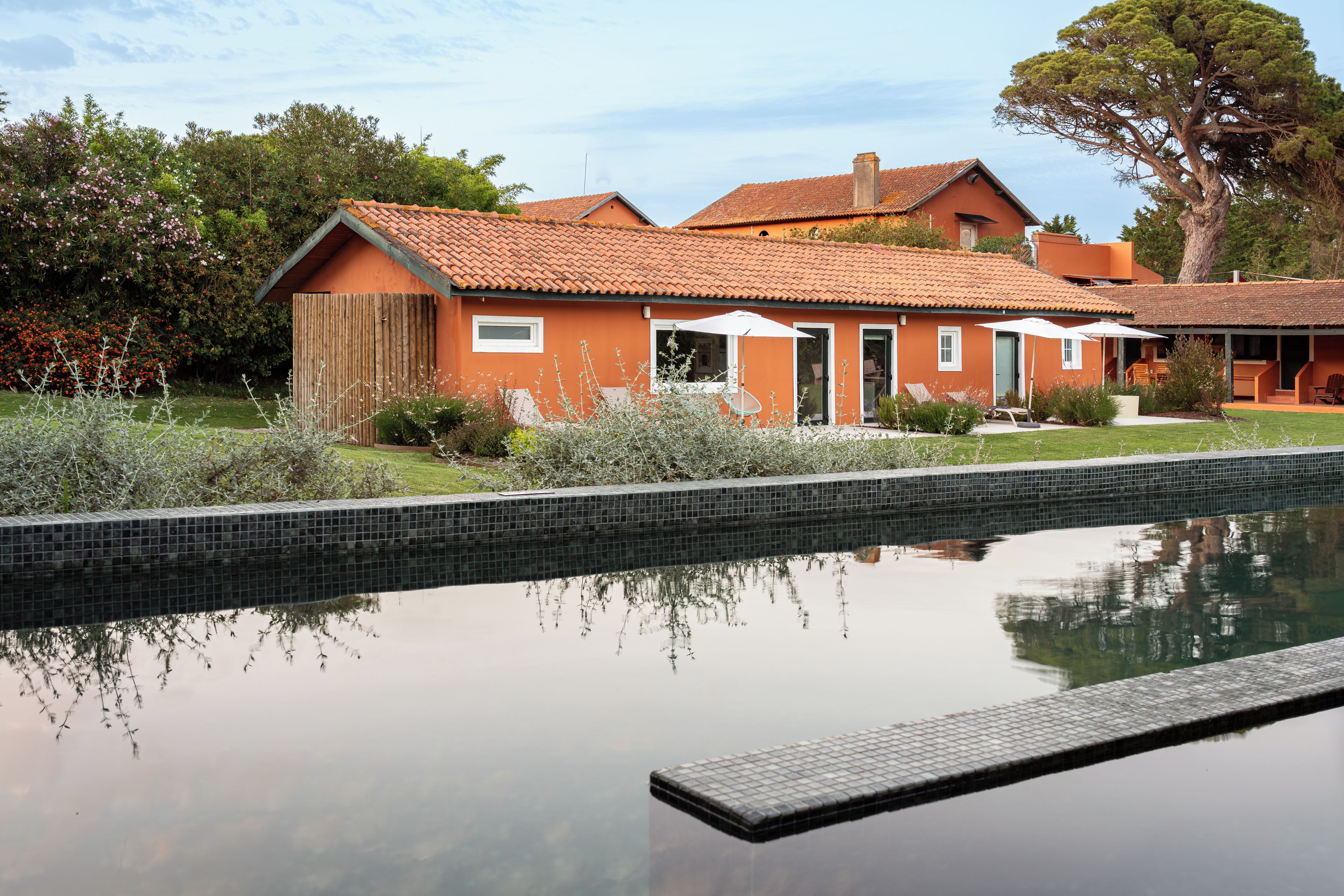 A two-story house with a swimming pool in front.