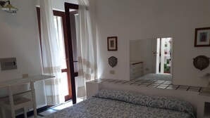 Une chambre à coucher avec un lit, un bureau et un miroir.