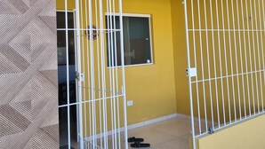 A yellow building with barred windows and a tiled floor. - Beach house in Itamaraca (Jaguaribe Ilha de Itamaracá)