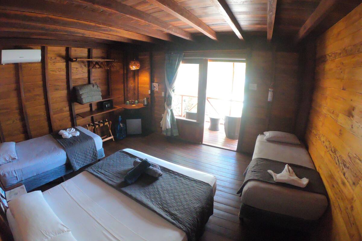 A cabin with two beds, a small table, and a bench.