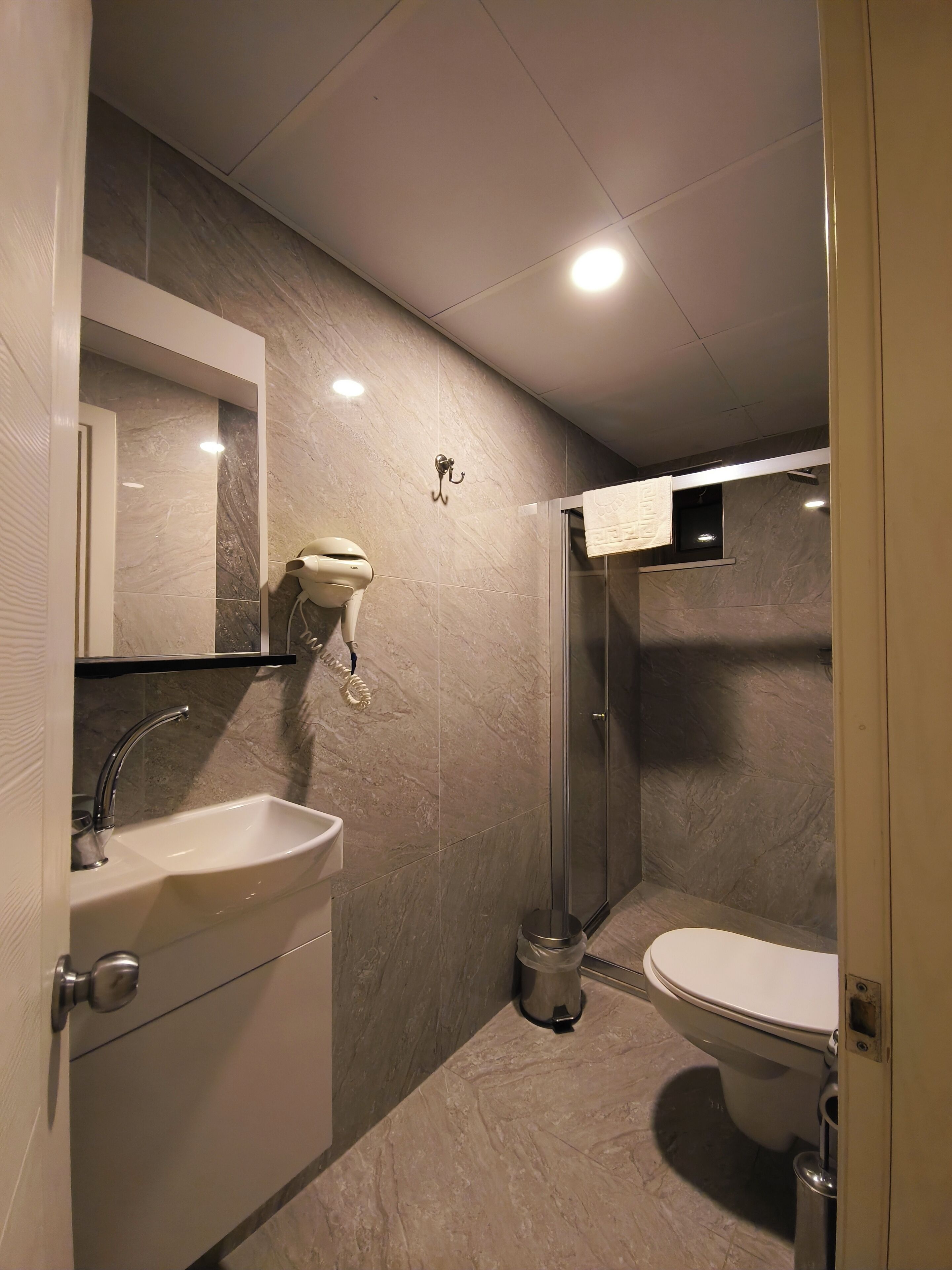A modern bathroom with a sink, toilet, and shower.