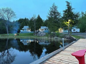 Une propriété située au bord d’un lac, dotée d’un quai, d’un petit étang et d’une rangée de maisons.
