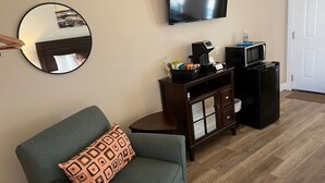 Ein Wohnzimmer mit Sofa, Couchtisch, Schrank, Fernseher und Mikrowelle.
