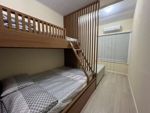 A bunk bed with a wooden ladder, a small bedside table, and a window with blinds. - AP 30 Especial Residencial Solavir (Bombinhas)