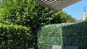 An outdoor seating area with wicker furniture and a patterned rug. - Lovely 3-star country house, ideal for a family. (LEUTENHEIM)