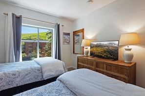 A hotel room with two beds, a television, a wooden dresser, and a window with curtains. - Park Station 146 Old Town, Main Street/Free Parking/Hot Tubs/Pool/Town Lift (Park City)