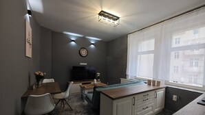Una cocina compacta con comedor, una isla integrada y un amplio ventanal que proporciona luz natural.