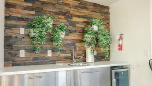 Eine Küche mit Holzrückwand, Edelstahlmöbeln und einem integrierten Geschirrspüler.