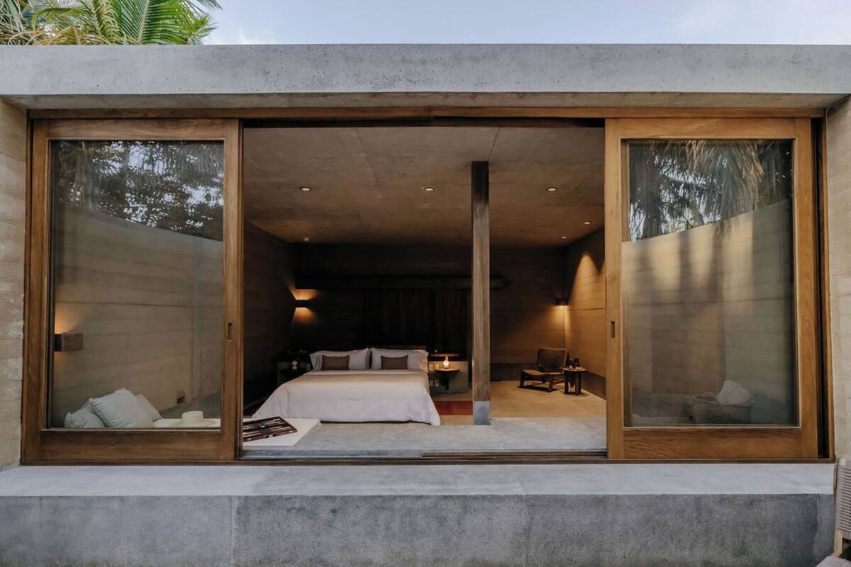 A modern bedroom with a large bed, a desk, and a chair.