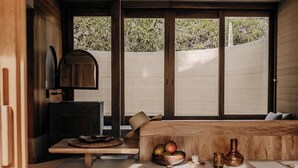 Une cuisine moderne dotée d’un four encastré, d’un plan de travail en bois et d’une grande fenêtre qui laisse entrer la lumière naturelle.