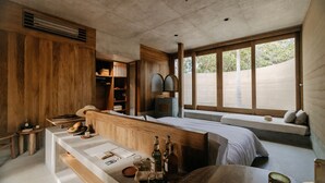 Une pièce moderne avec un banc en bois, une petite table sur laquelle sont posées des bouteilles et une fenêtre donnant sur un beau paysage.