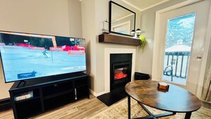A living room with a TV, fireplace, and a dining table.