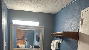 Een badkamer met een grote spiegel, een wastafel en een handdoekrek.