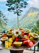 Una bandeja de frutas con una vista de las montañas al fondo.