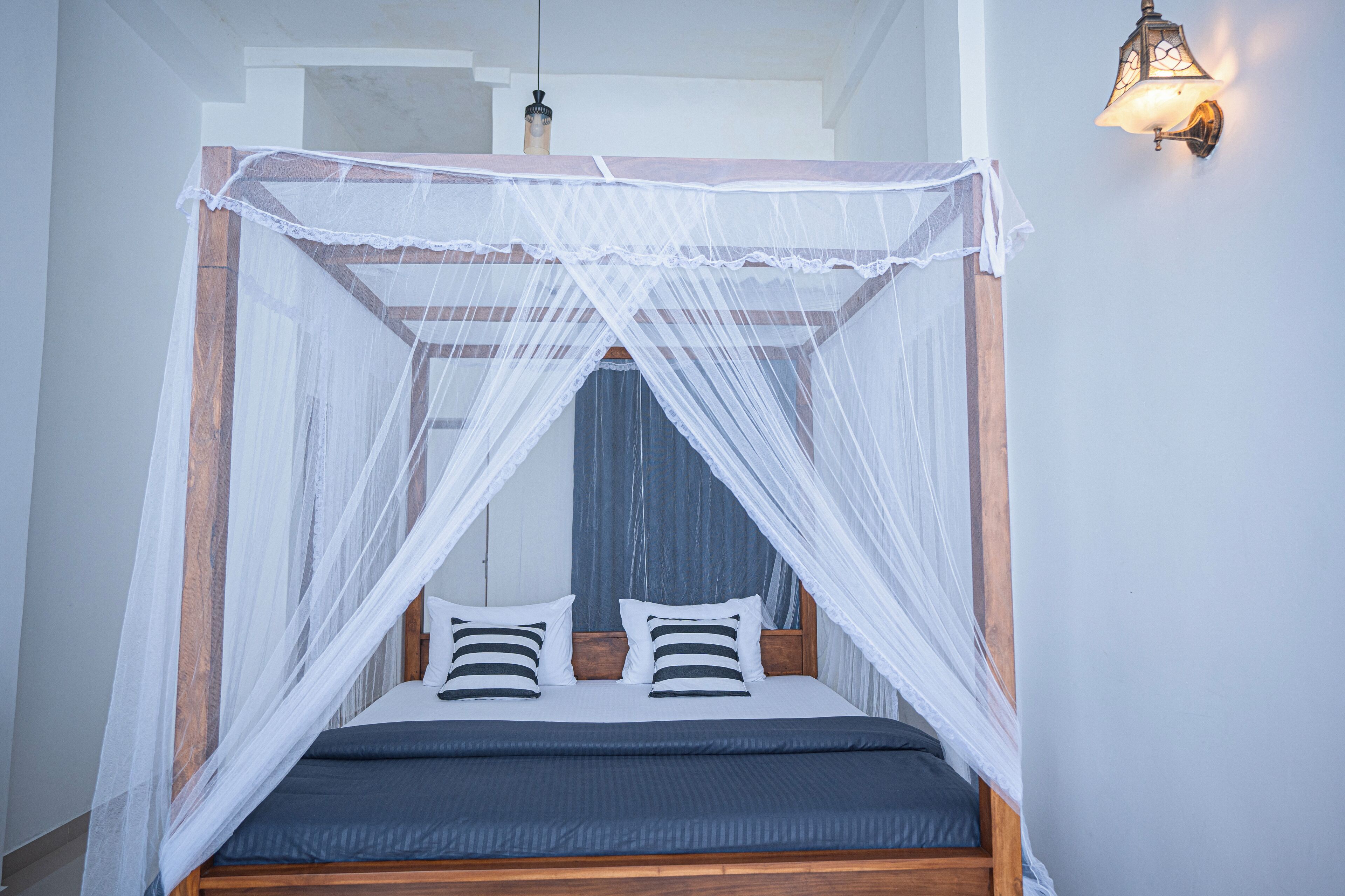 A bed with a wooden frame and a white canopy.