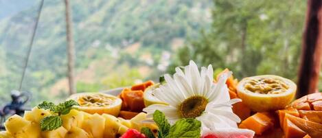 A fruit platter with a mountain view in the background.