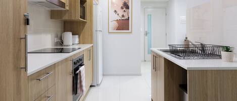 A modern kitchen with wooden cabinets, stainless steel appliances, and a tiled backsplash.