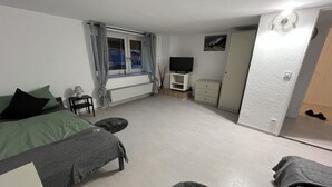 A bedroom with a bed, a TV, a wardrobe, and a window with curtains. - Small but nice in Nöpke. (Nöpke)
