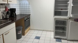 A compact kitchen with a stove, oven, and a refrigerator. - Small but nice in Nöpke. (Nöpke)