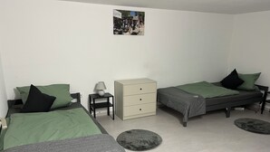 A room with two beds, a small cabinet, a nightstand, and a lamp. - Small but nice in Nöpke. (Nöpke)