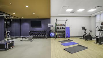 Un gimnasio con equipo de ejercicio, mancuernas y colchonetas.
