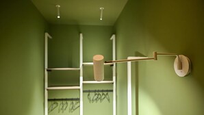 A bathroom with green walls, a white towel rack, and a towel holder.